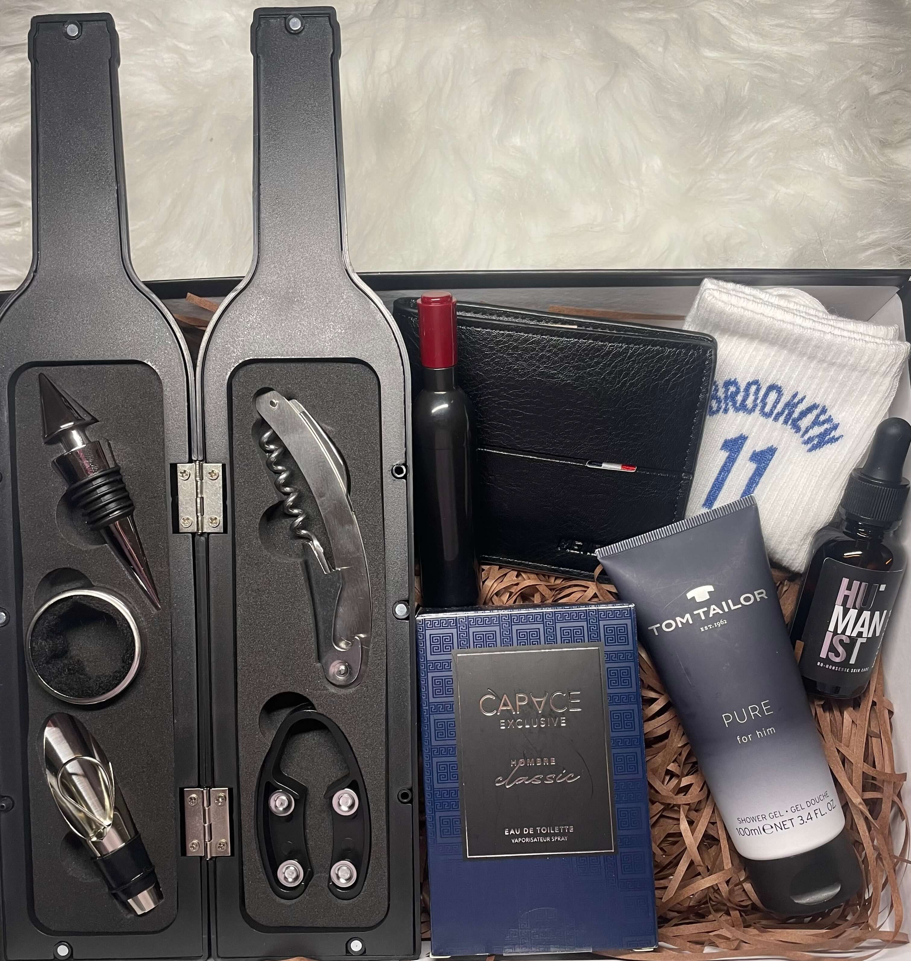 Coffret cadeau homme avec kit sommelier ouvert en forme de bouteille, parfum, chaussettes, gel douche, portefeuille, ouvre bouteille en forme de bouteille et huile visage et barbe.