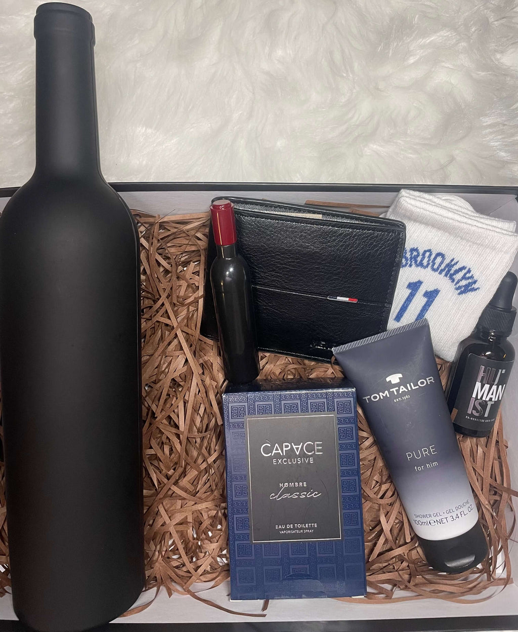 Coffret cadeau homme avec kit sommelier fermer en forme de bouteille, parfum, chaussettes, gel douche, portefeuille, ouvre bouteille en forme de bouteille et huile visage et barbe.